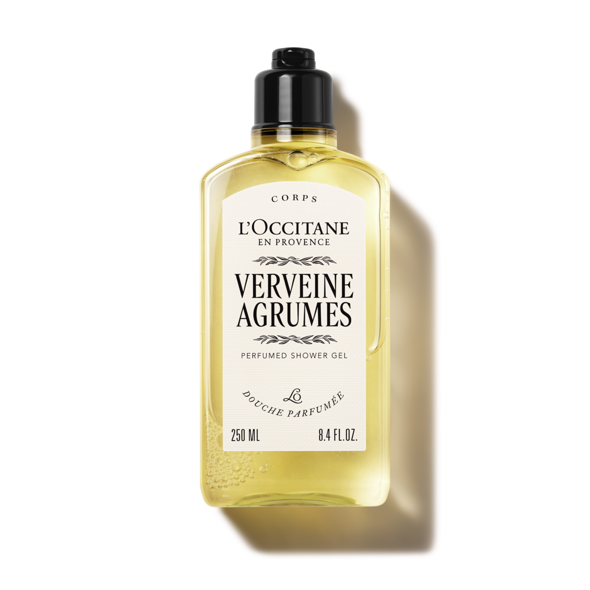 L'Occitane Verbena Citrus Body Lotion 250ml bottle on a natural background with verbena leaves and citrus fruits. - thumbnail 2